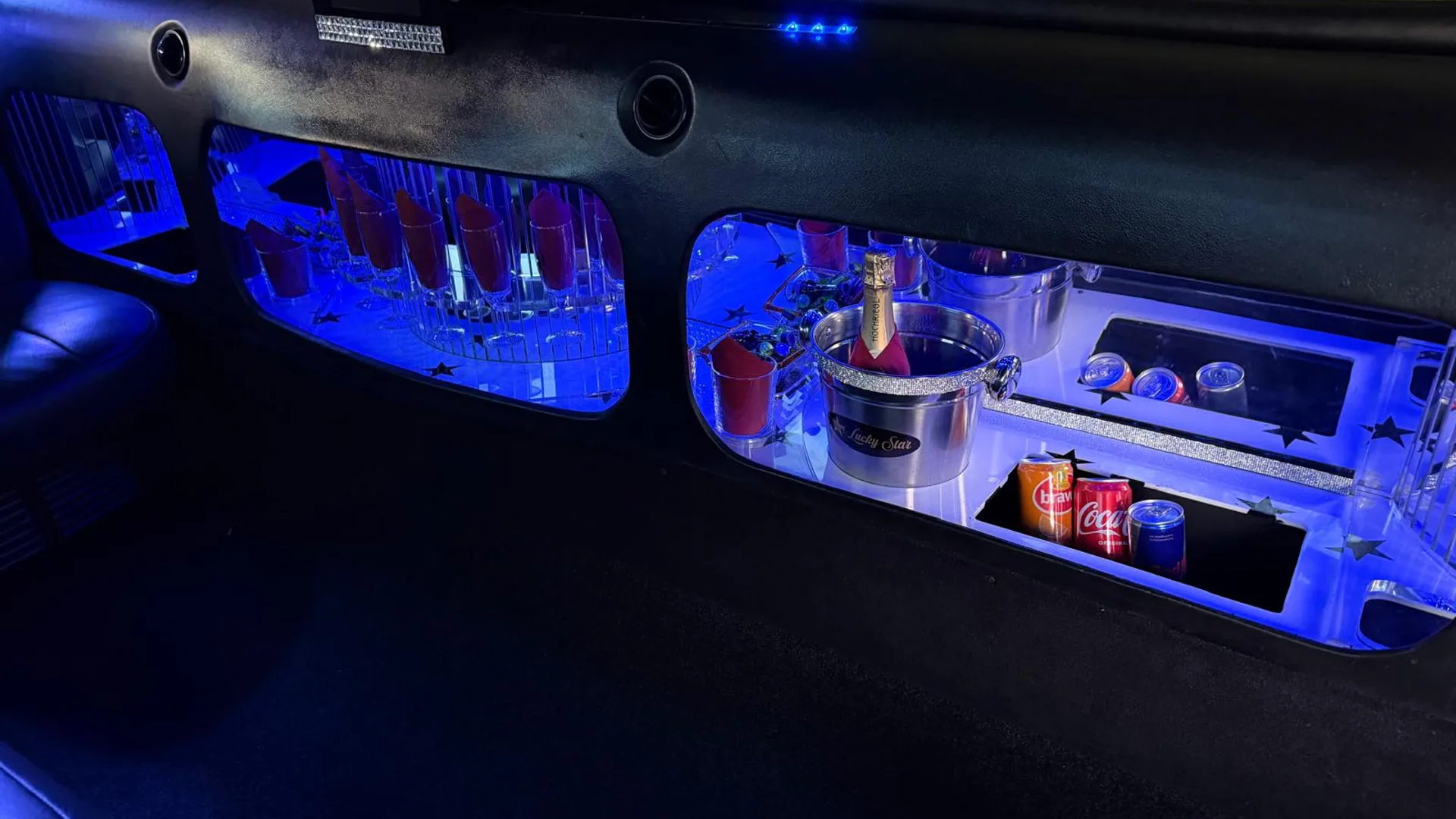 Lucky Star Innenraum - blau beleuchtete Display-Vitrinen mit Champagner und Getränken